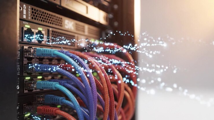 Cavi di rete vivaci collegati a un rack di server con effetti digitali scintillanti che evidenziano le innovazioni nella trasmissione dei dati e nella connettività in un moderno data center.