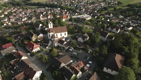 drone footage moving out to reveal aach's historic old town with a focus on the church tower, showcasing the surrounding village and scenic landscape.
