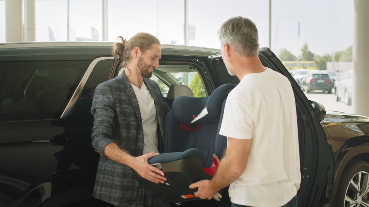 cliente y vendedor inspeccionando el asiento del coche en una sala de exposiciones