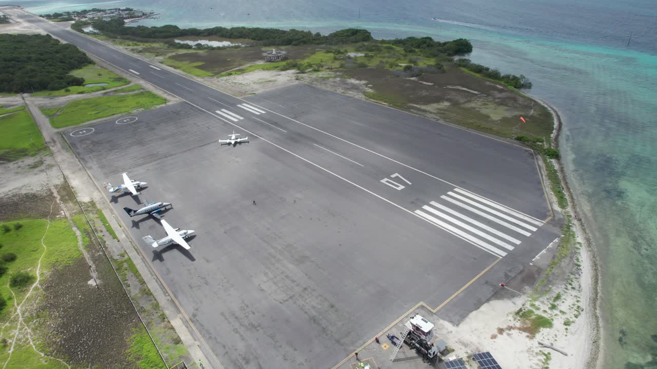 Aerial view of Los Roques runway with parked planes by the ocean