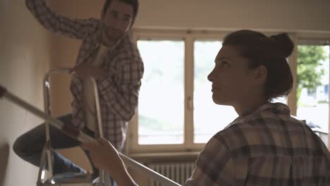 couple painting walls together in their new house