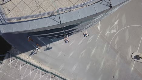 Aerial-reveal-shot-above-business-roof-with-industrial-climbers-working-on-window-cleaning-with-rope-rigging