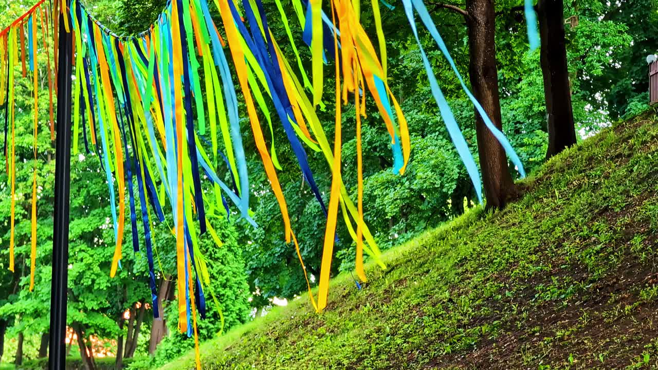 Colorful streamers hanging in green park setting during summer celebration event
