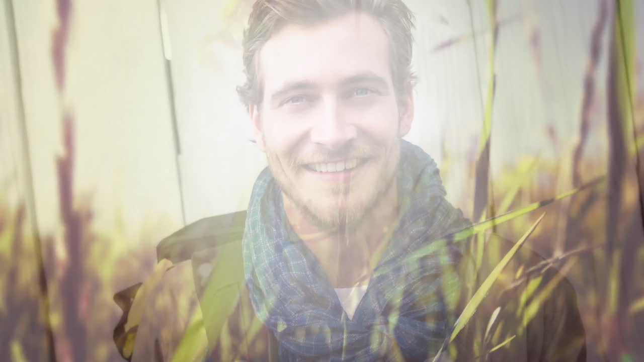 animación de la hierba moviéndose sobre el hombre sonriente al aire libre en un día soleado