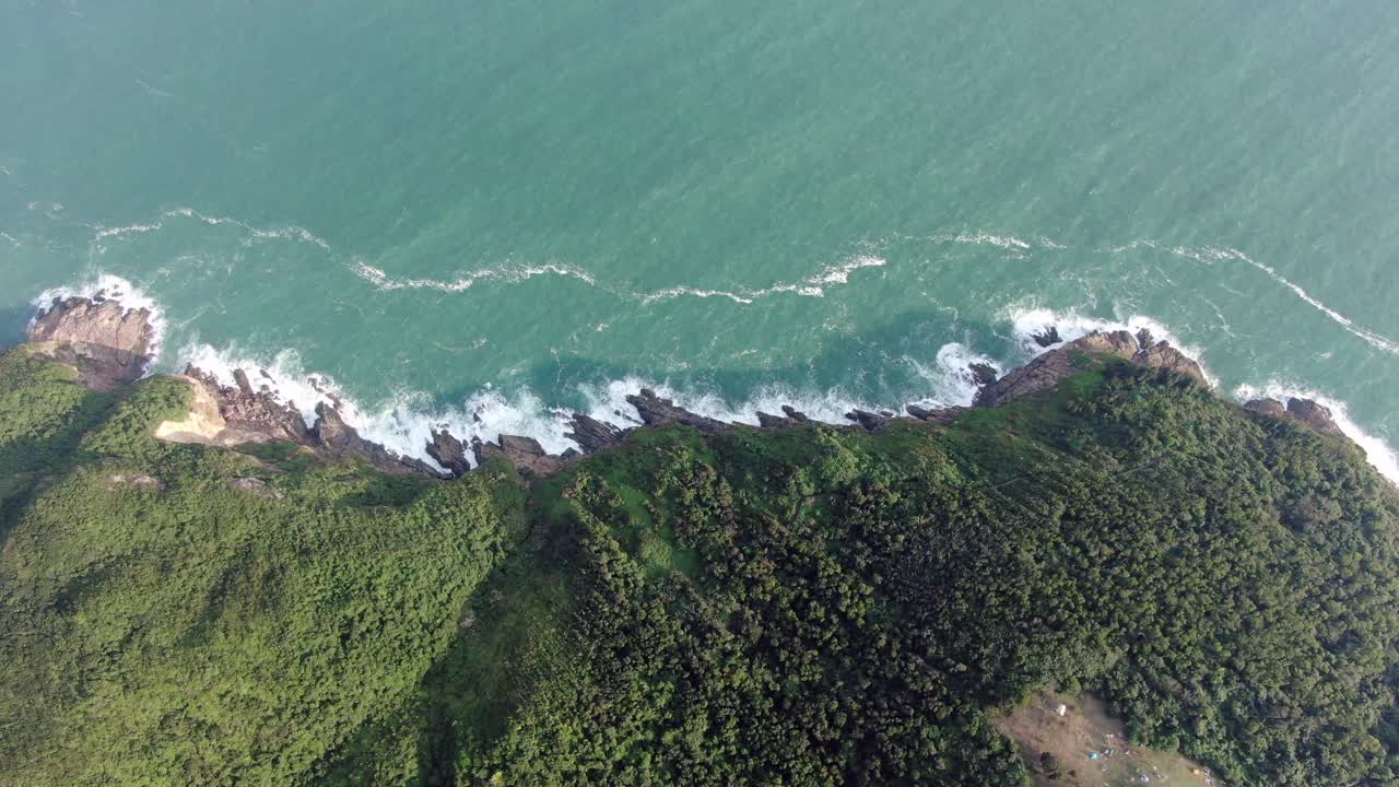 vista aérea de una isla rocosa irregular, rodeada de naturaleza verde y exuberante y agua de la bahía de hong kong