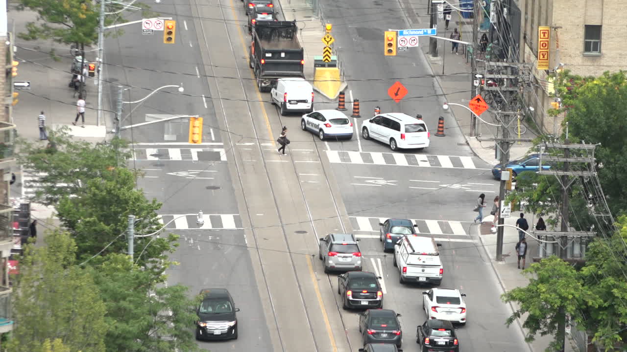 Construction never ends in Toronto. A busy intersection shot from above is congested due to streetcar track repair. The traffic is terrible in Toronto. These repairs don't help.