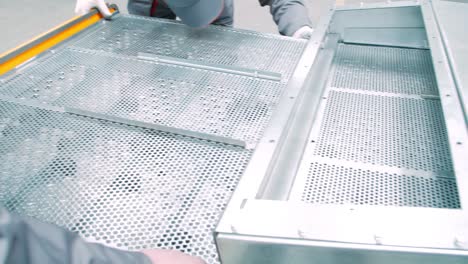 installation of industrial equipment using aluminum grids. workers at workshop