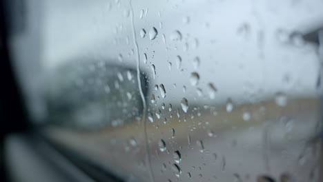 Espejo-Del-Coche-En-Un-Día-Lluvioso-Gotas-De-Agua-En-El-Cristal-Del-Coche