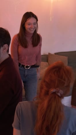 excited friends dancing while enjoying weekend party in living room at home