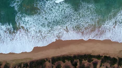 vertical static drone footage of waves hitting the beach at point lonsdale, victoria, australia