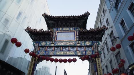 gate and red lanterns in china town area in london uk in slow motion