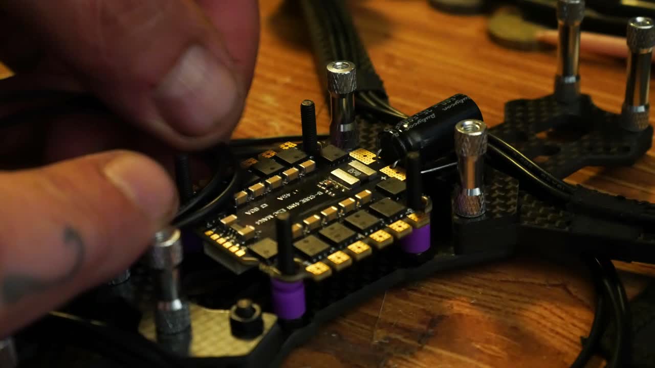 Close up preparing wiring for FPV drone hobby build on the controller circuit board