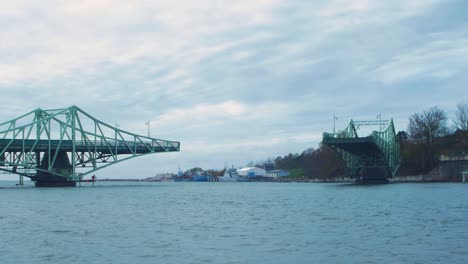 Timelapse-of-closing-Oskara-Kalpaka-swing-bridge-in-Liepaja-in-cloudy-autumn-day,-wide-shot