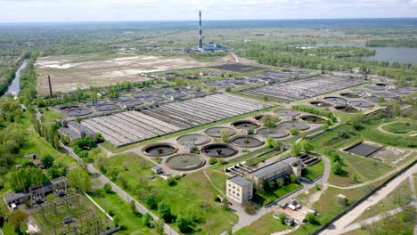 aerial shot of a wastewater treatment plant and distant skyline. big city waste processing concept