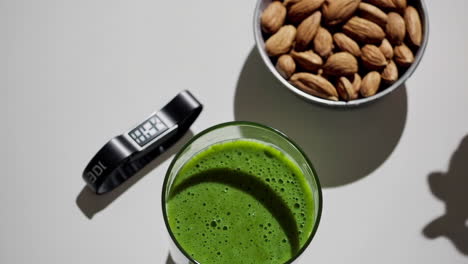 healthy green smoothie with almonds and fitness tracker