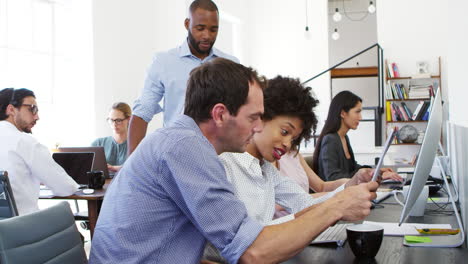 Two-men-and-woman-work-together-in-open-plan-office,-slo-mo