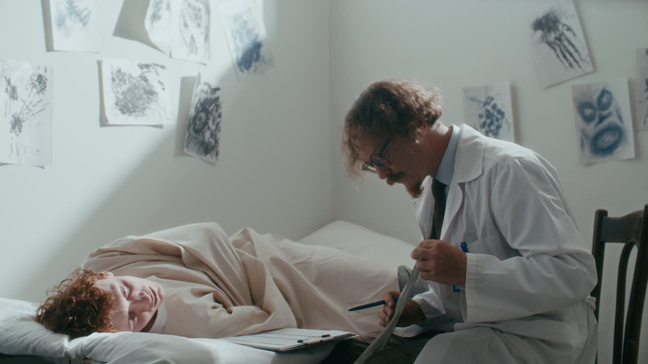 Psychiatrist Reviewing Patient Artwork during Therapy Session in Hospital