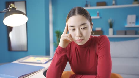 frustrated young asian woman looking at laptop unhappy.