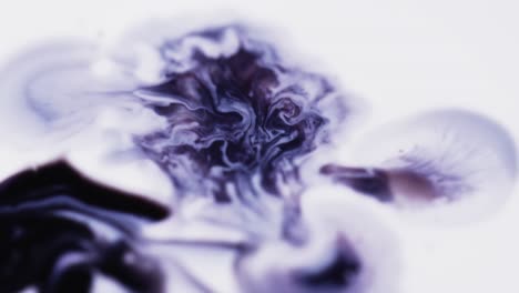 Slow-motion-video-of-purple-watercolor-ink-mixing-in-water-against-grey-background