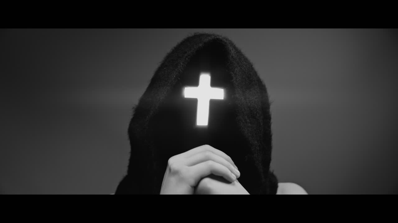 Masked man with cross of light glowing on his face moves his head up