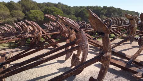 Tiro-Hacia-Atrás-De-Anclas-Oxidadas-Almacenadas-En-Filas-En-El-Puerto-De-Barbate,-Cádiz,-España