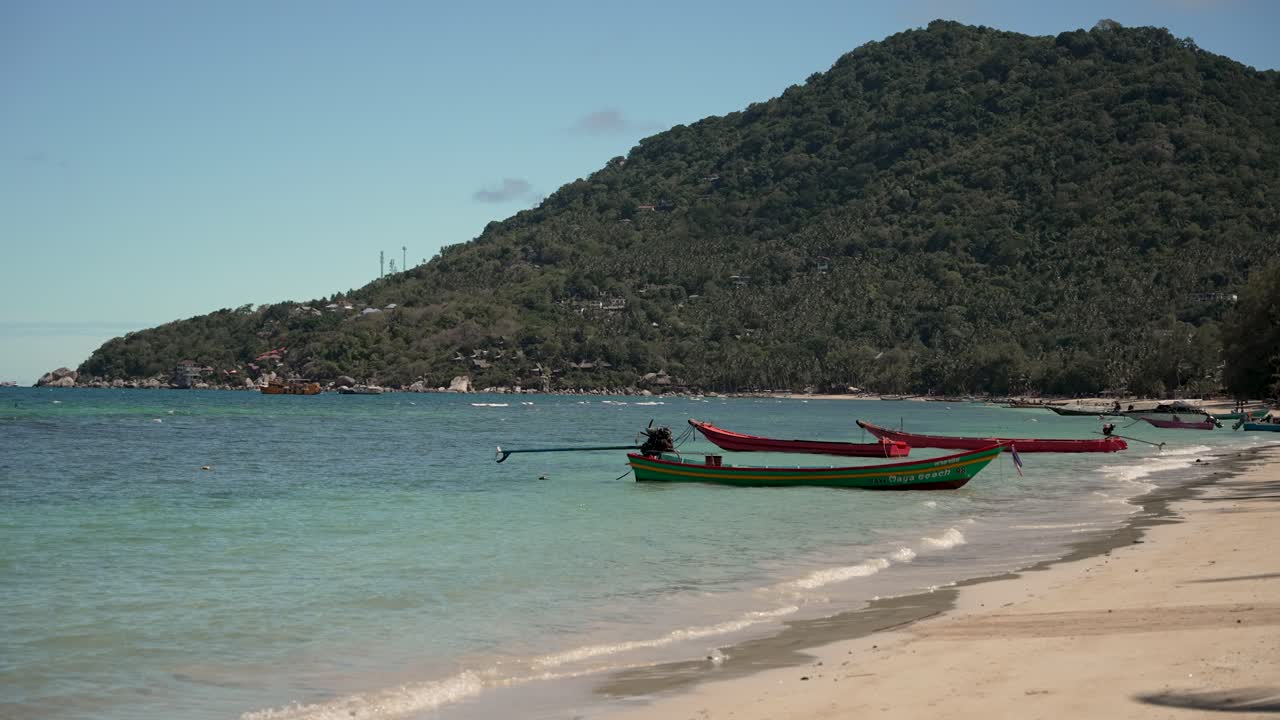 태국에서 은 물과 울창한 언덕이 있는 열대 해변 에 정박한 나무 롱보트의 조용한 풍경