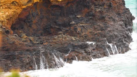 dynamic waves crash against rugged cliffs under natural light, showcasing the dramatic coastal landscape of great ocean road, australia