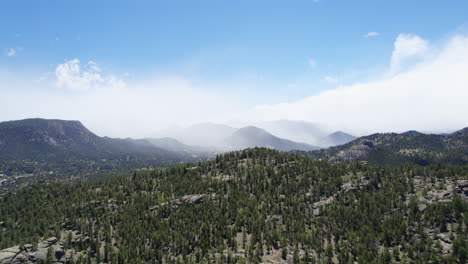 4k 空中無人機拍攝在高山森林山丘上空, 背景是高山脈, 覆蓋著低雲和霧<unk>