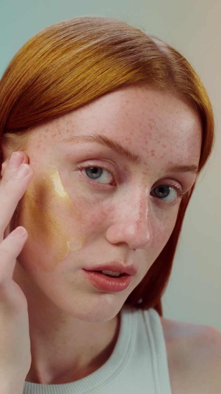 mujer aplicando una máscara de oro