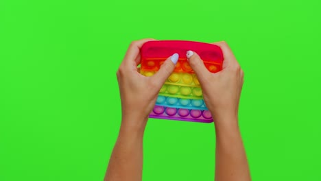 a person's hands are holding a rainbow pop it fidget toy.