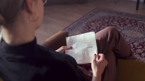 woman reading a handwritten letter at home