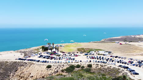 Powered-parachute-resort-in-San-Diego-against-blue-ocean-water,-drone-view