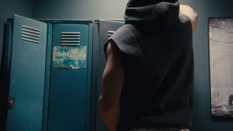 man putting on shoes in a locker room