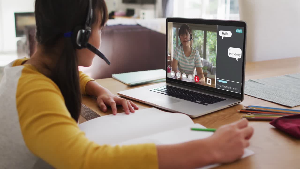 Schoolgirl using laptop for online lesson at home, with girl talking and web chat on screen