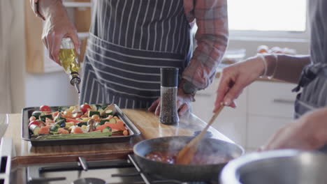 middle aged caucasian couple preparing meal, cooking together in kitchen at home, slow motion