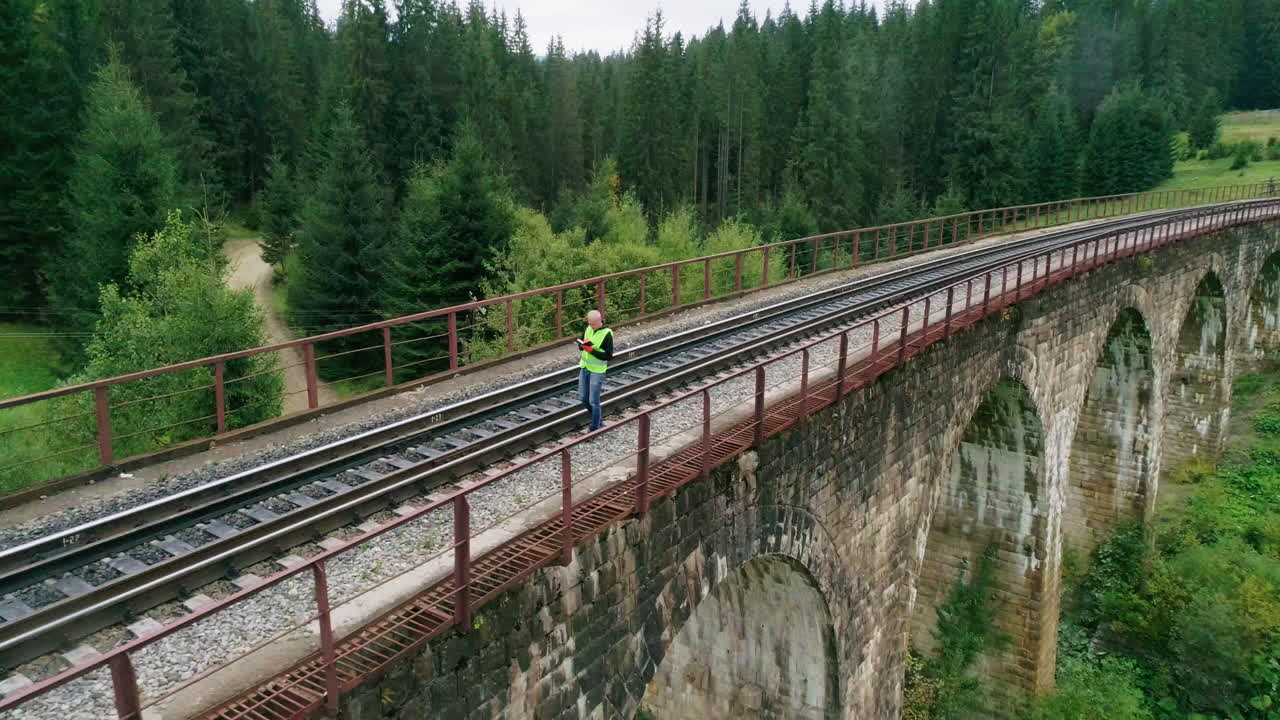 hombre trabajando en un puente ferroviario en un bosque