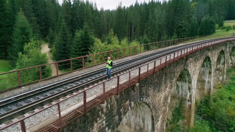 man working on a railway bridge in a forest