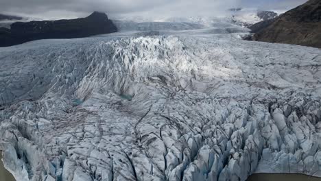 Aerial view of the beautiful iceberg-filled lagoon of Fjalls&aacute;rl&oacute;n in Iceland from the beginning of the lagoon to the top with incredible ice views in different shapes and mountains during summer time