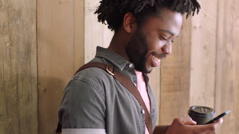 Young-man-having-coffee-and-using-a-phone-against