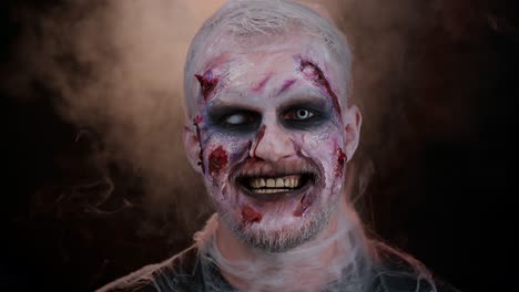 unerwartetes auftreten eines unheimlichen mannes mit schrecklichem halloween-zombie-make-up, der versucht zu erschrecken