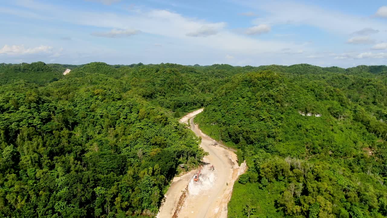limpieza del paisaje forestal para construir una nueva carretera sinuosa en indonesia, vista aérea