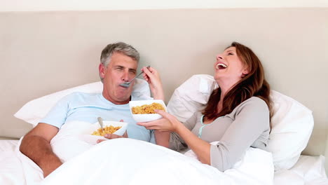 couple eating while lying in bed