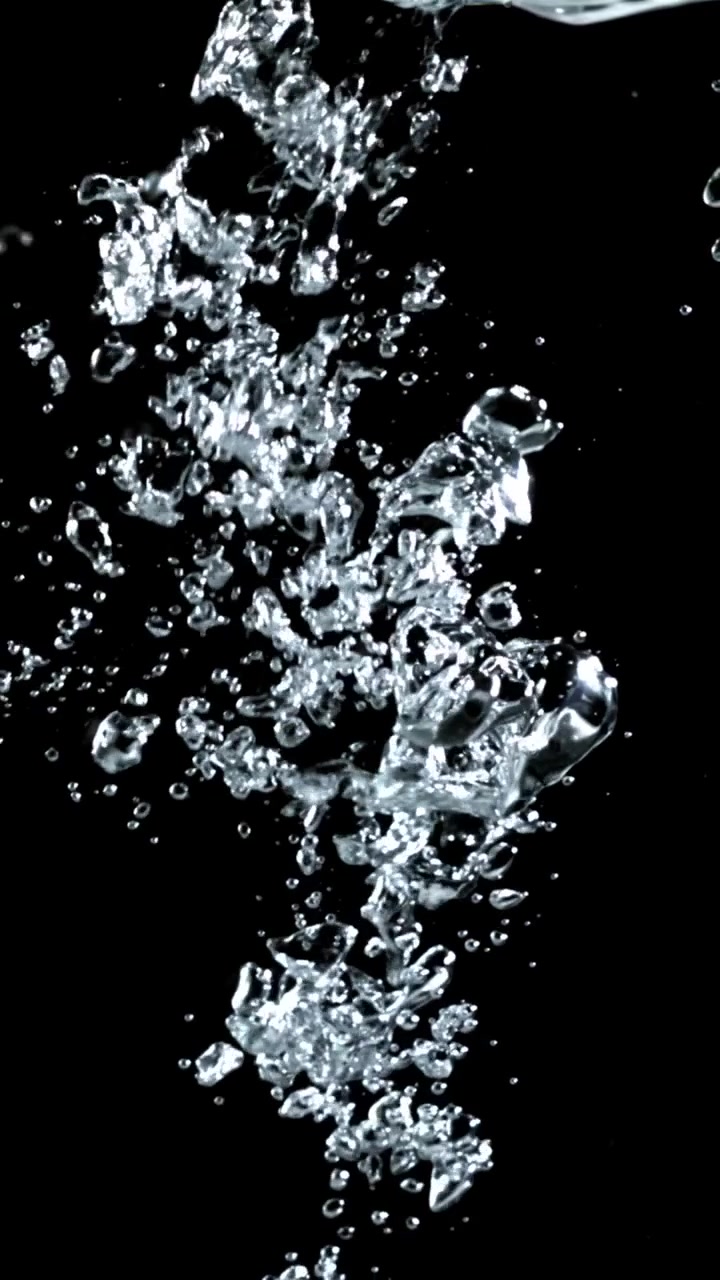 Acqua Limpida che si Versa e Bolle d'Aria che Salgono su Sfondo Nero
