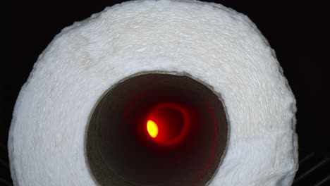 starting outside a paper towel roll, moving deep inside the tube towards an offset red light at the end