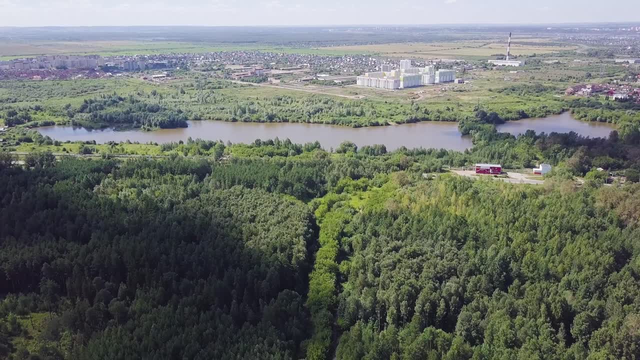 Aerial View of a City and Forest with a Lake