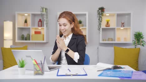 Home-office-worker-woman-applauding-what-she-sees-on-laptop.