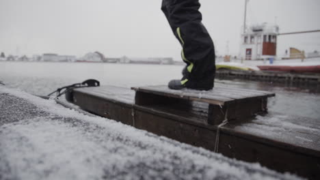 climbing frozen boat deck in freezing cold at harbour closeup