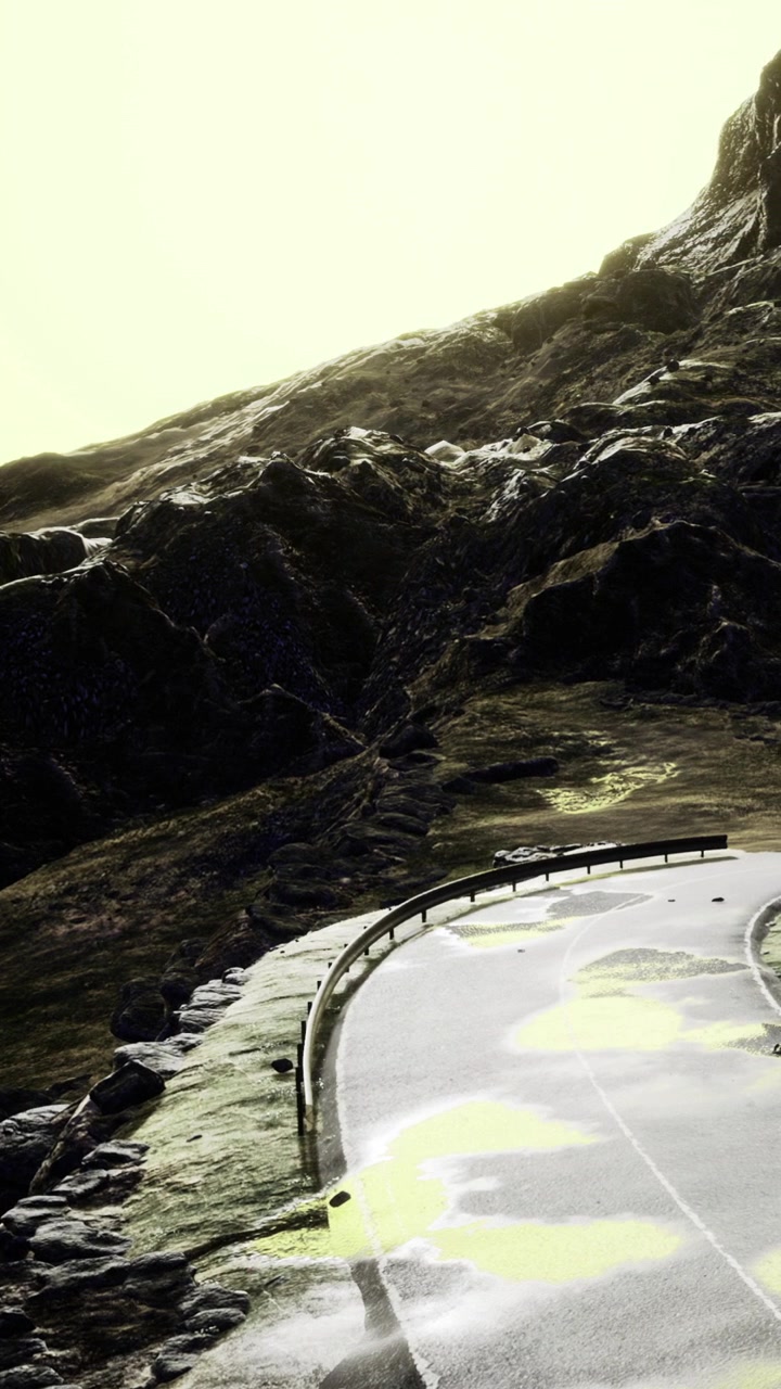 Mountain road curves along rocky landscape during bright daylight