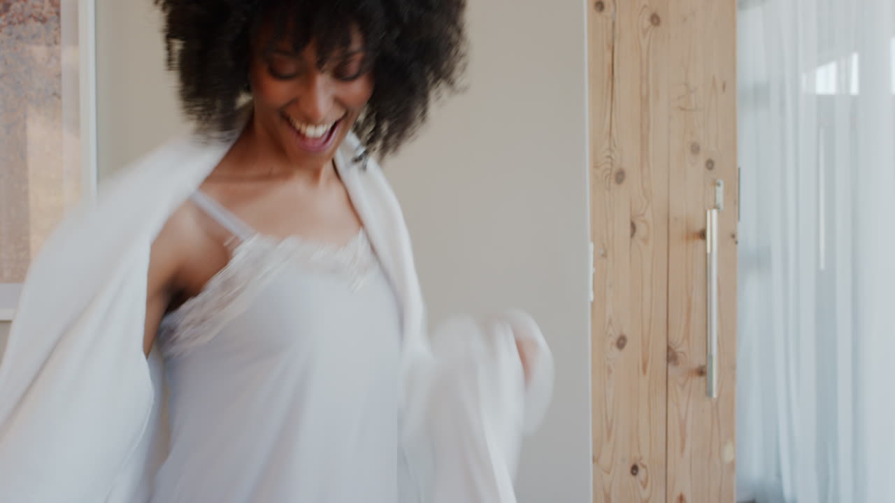 happy woman dancing at home wearing pajamas having fun celebrating lifestyle achievement enjoying happy dance in penthouse apartment