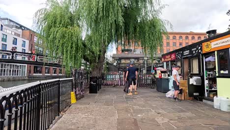 people walking by shops and canal